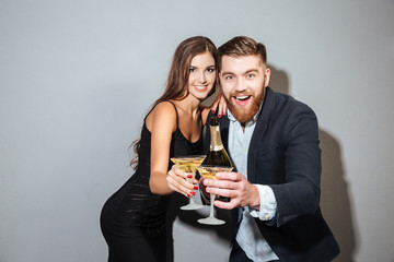 Happy friends with champagne looking at camera