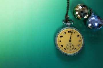 Christmas balls and clock on the green background
