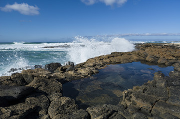 Waves rolling in at the Atlantic ocean, smashing on cliffs produ