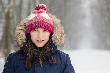 Girl in white snowy forest during beautiful snowfall