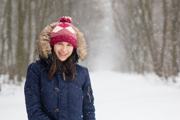 Girl in white snowy forest during beautiful snowfall