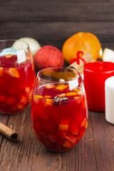 Mulled wine with citrus in glass on a dark wooden background