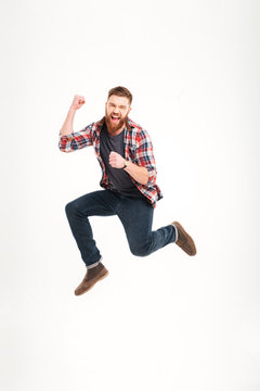 Casual Young Man In Plaid Shirt Jumping In The Air