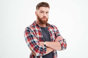 Satisfied bearded man in plaid shirt with arms folded