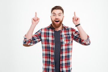 Portrait of excited man in checkered shirt pointing fingers up