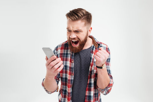 Portrait Of Angry Young Man Screaming On His Mobile Phone