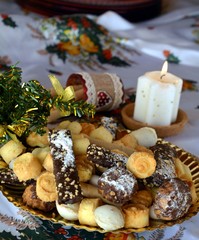 Christmas cookies on a plate and white lighted candle