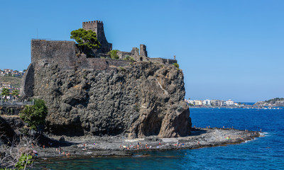Fototapeta na wymiar The Aci Castello's castle is situated on a ridge of lava, dominating the surrounding square. Built by the Normans from black lava stone between 1076 and 1081.