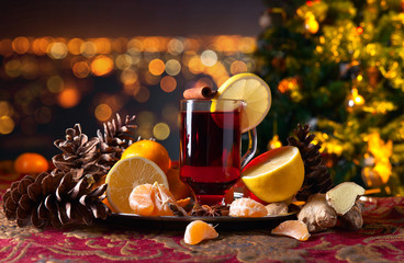 Mulled wine with spices and tangerines before Christmas tree