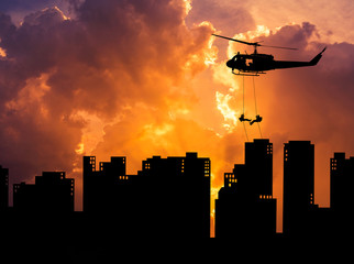    silhouette soldiers in action rappelling climb down from helicopter with military mission...