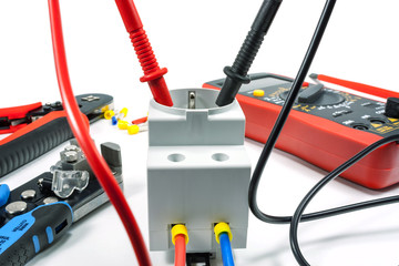 Measurement of voltage in electrical outlet with a multimeter on a white background