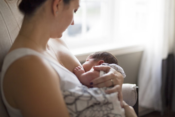 Mother breastfeeding her little baby boy in  arms. - obrazy, fototapety, plakaty