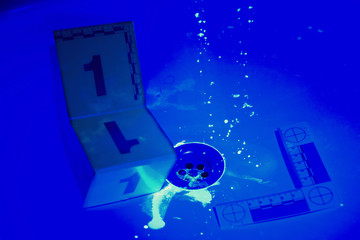 Developing of evidence of blood with ultra violet light in bathroom