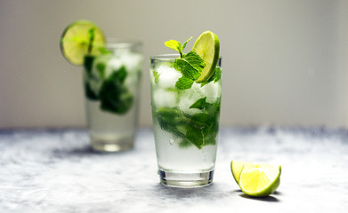 Mojito cocktail with lime and mint in glass on a white background
