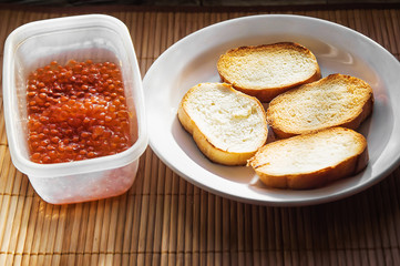 Pile of toasted bread slices on a single white plate.