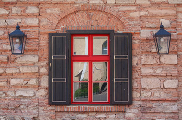 Red wooden window and brick wall. Urban