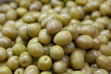 Green whole olives in oil close up