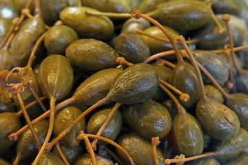 Green pickled big capers close up background