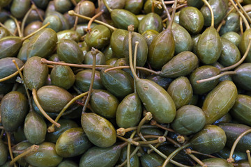 Green pickled big capers close up background