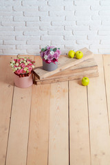 flowers and apple on wooden planks