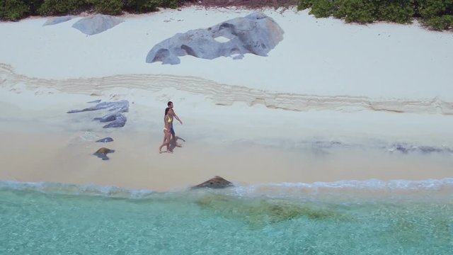 aerial video of a couple walking on tropical beach, Virgin Gorda, British Virgin Islands