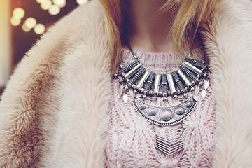 Elegant winter outfit. Close up of massive necklace. Boho style. Fashionable girl on the street....