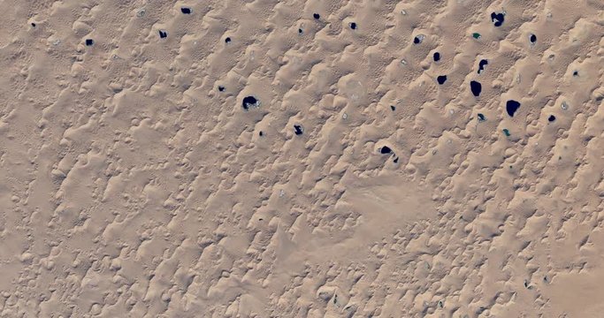 High-altitude overflight aerial of dunes in the Badain Jaran Desert, China. Clip loops and is reversible. Elements of this image furnished by NASA 