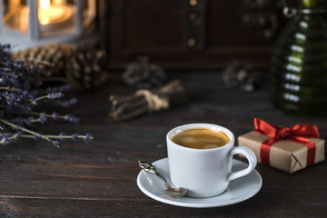 cup of aroma black espresso on wooden table with little present, lavender and decor things