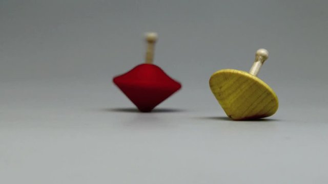 Two wooden and colorful spinning tops.