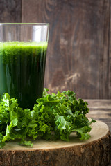 Smoothie with kale in glass on wooden background.Copyspace
