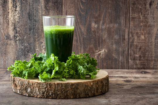 Smoothie with kale in class on wooden background.Copyspace
