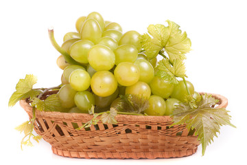 green grapes in a wicker basket isolated on white background