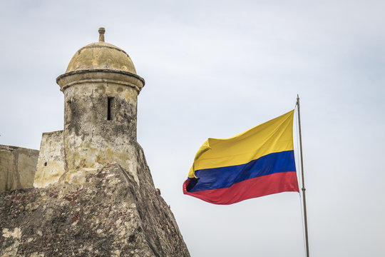 Bandera de Colombia al lado de torre de vigilancia castillo San