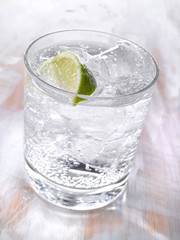 Gold drink with ice. Photographed on a light wooden background. Light illumination.