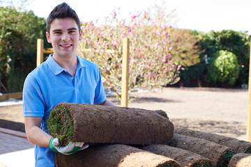Landscape Gardener Laying Turf On New Lawn