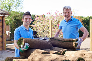 Landscape Gardeners Laying Turf For New Lawn