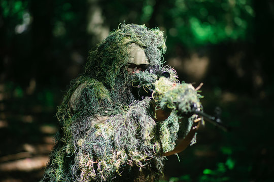 Photographer wearing camouflage clothing in the forest, wildlife animal  photography with a camera and telephoto lens Stock Photo - Alamy