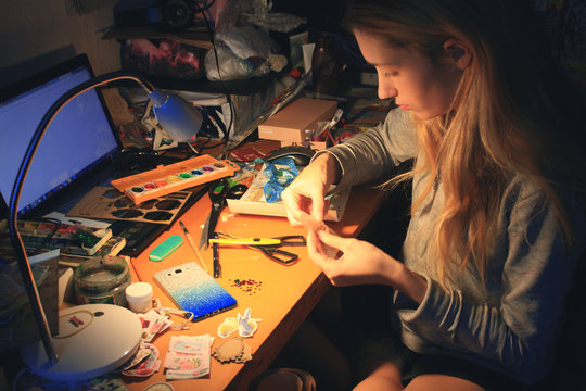 caucasian blond young woman do craft decoration at home