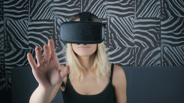 Close-up shot of woman getting experience in using VR-headset at home