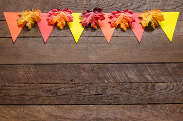 A colorful fall banner on  dark wood background with maple leave
