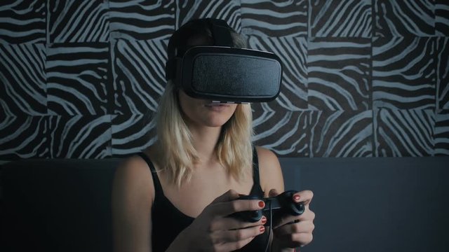 Virtual reality game. Girl with pleasure uses head-mounted display at home