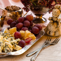Cheese and grapes on a silver platter.