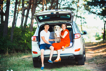 pregnant wife, husband and dog sitting in a car