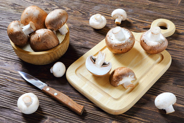 Portobello champignon in a wooden bowl and cutting board