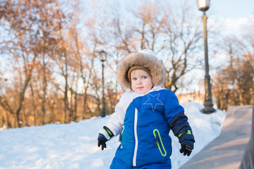 Baby in winter park looking on copy space