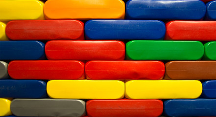 Bunte Bauklötze aus Plastik im Kindergarten zu einer Wand aufgetürmt