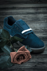 dark blue man's shoe and rose