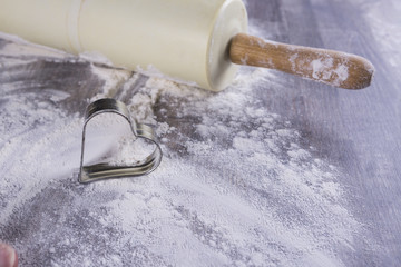 cookie cutter on dough with flour on wooden background