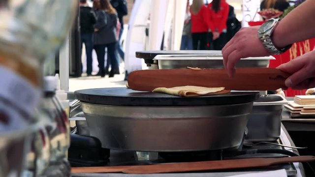 Man finishing a pancake, then sprinkle it with sugar