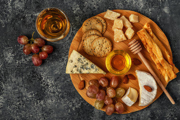 Assortment of cheese with honey, nuts and grape 